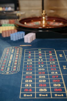 Close-up view of a roulette table with colorful chips and numbered layout in a casino setting.
