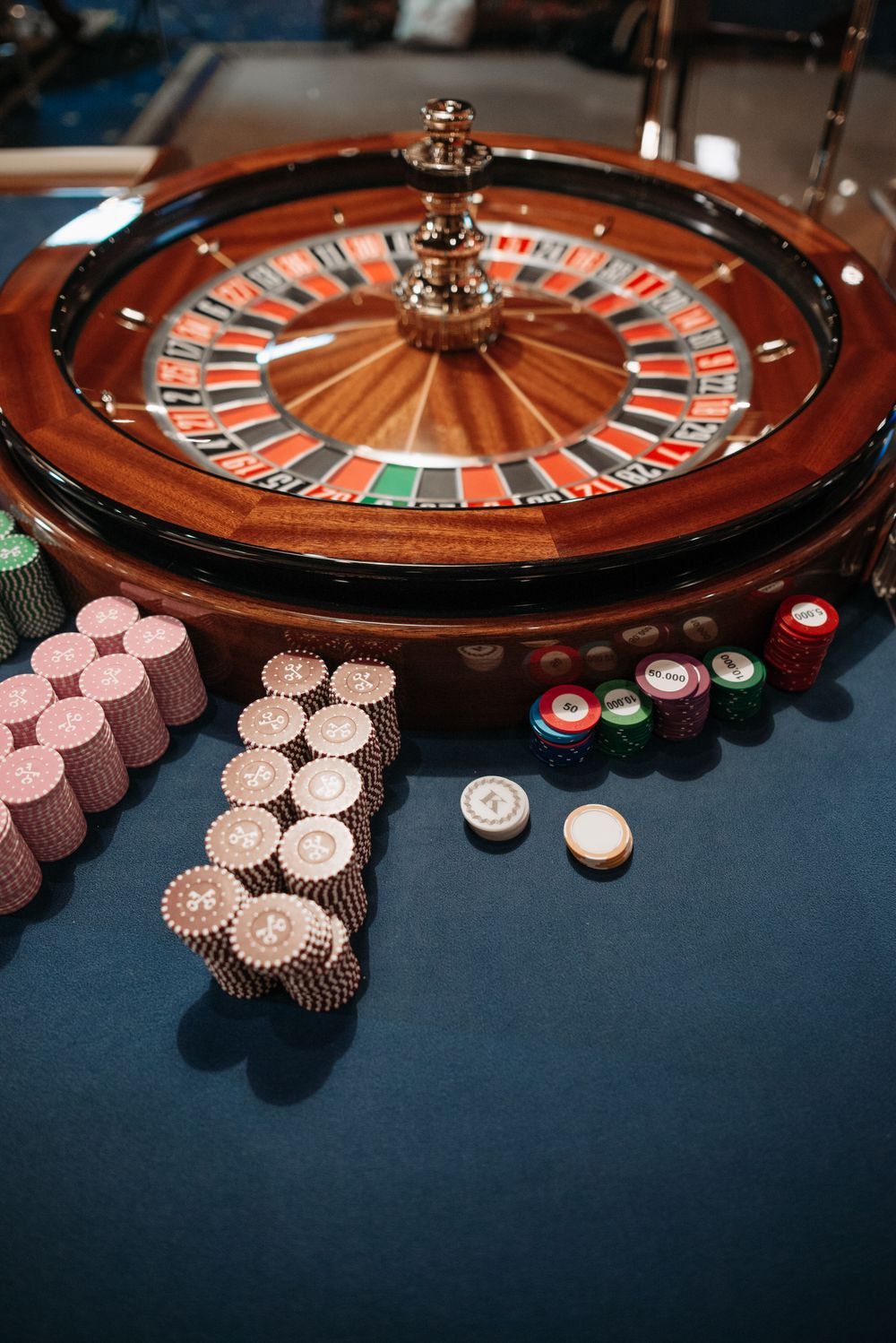 Roulette wheel beside neatly stacked casino chips on a gaming table