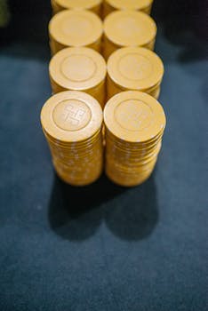 Close-up of yellow casino chips stacked on a dark surface, symbolizing gambling and luck.