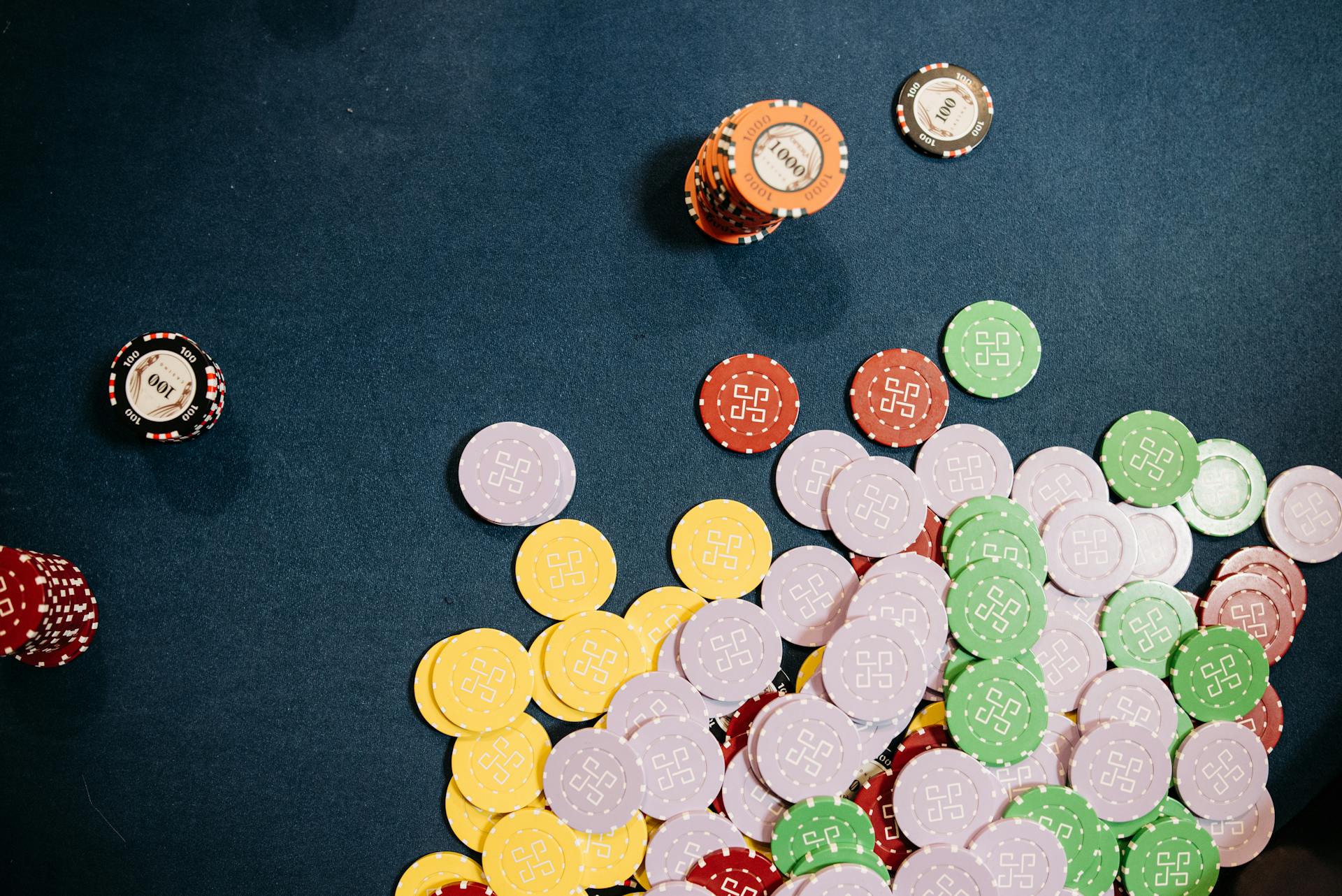 Top view of scattered casino chips in various colors on a table. Ideal for gaming themes.