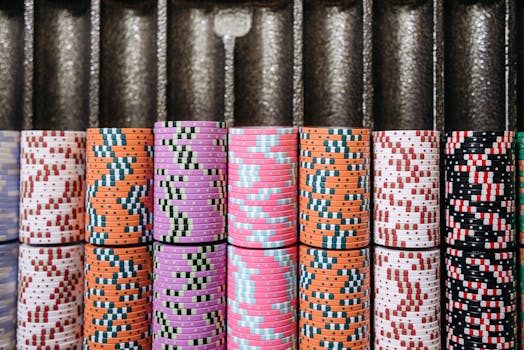 A close-up of colorful casino chips neatly stacked in rows, symbolizing the gambling experience.