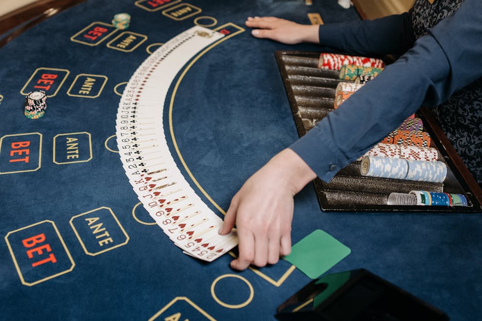 A casino dealer organizing playing cards on a gaming table with chips. Indoors setting.