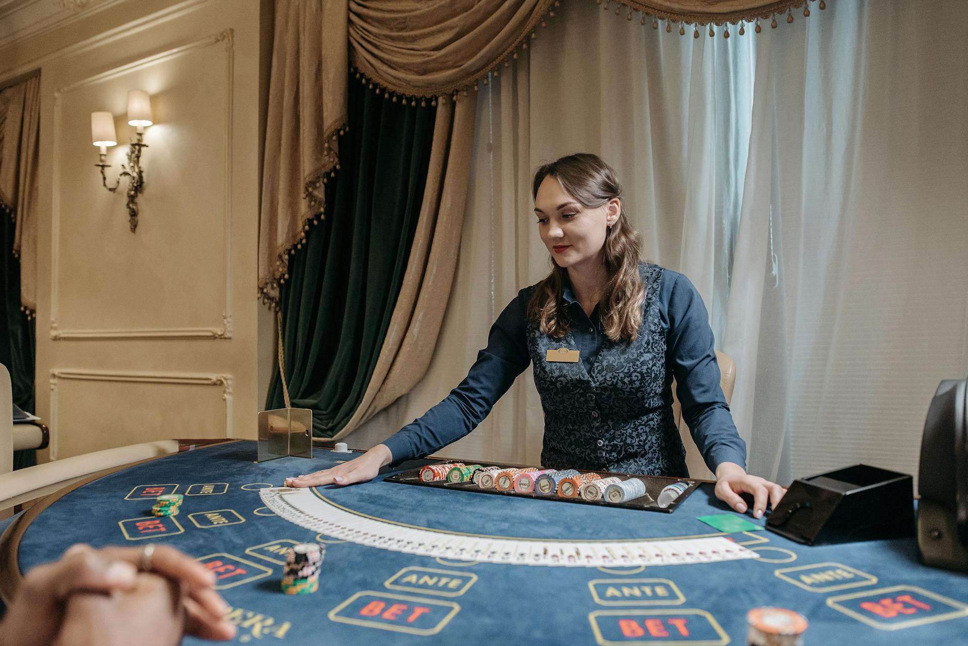 Casino dealer managing cards and chips in an elegant gambling setting.