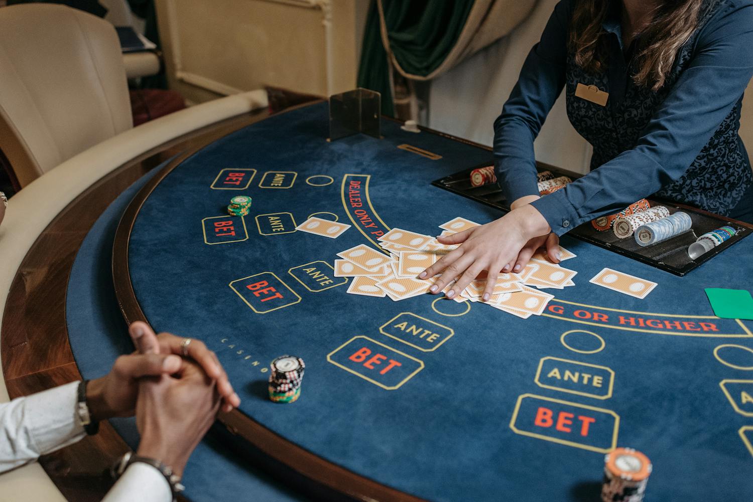 Casino dealer shuffling cards with chips