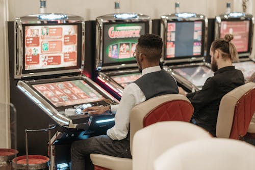 Men Sitting in Front of a Slot Machine