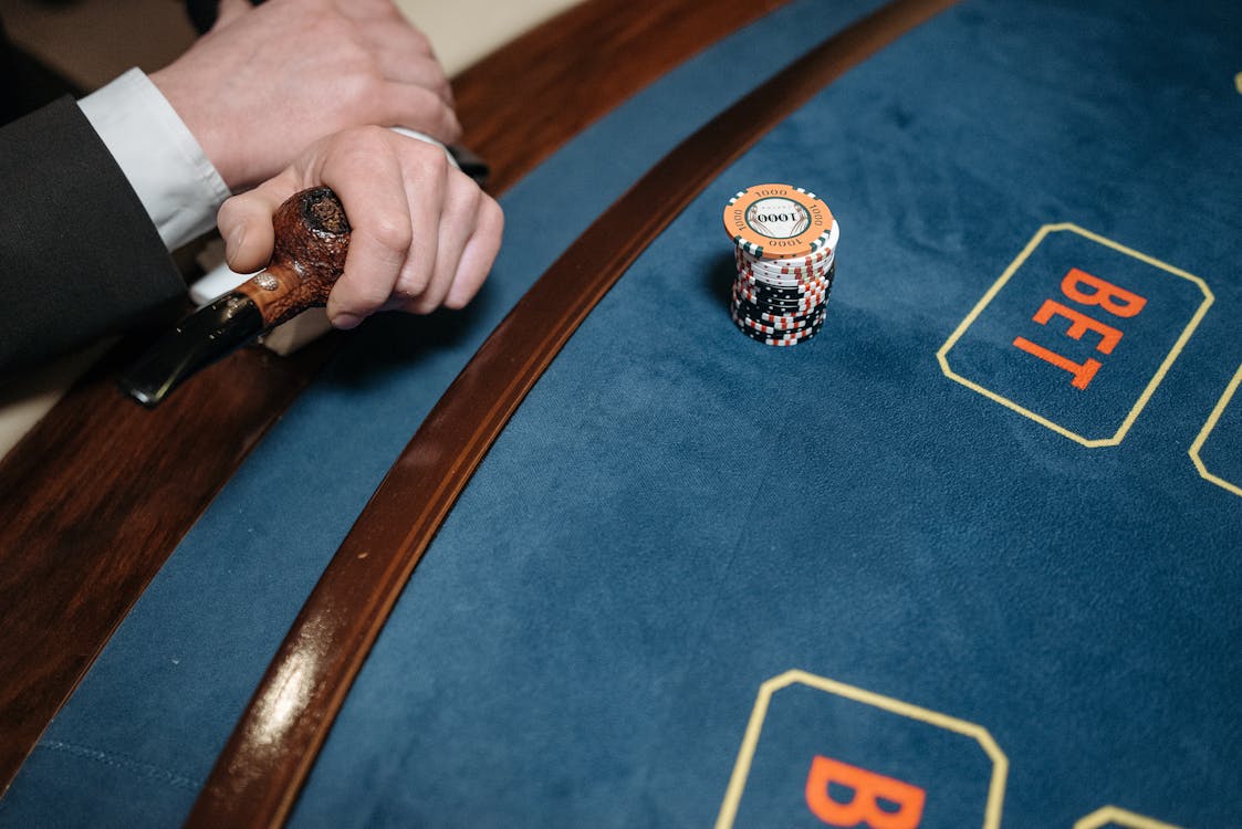 Free A Person Holding a Pipe Near the Gaming Table Stock Photo