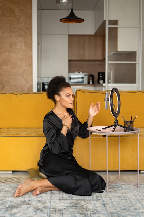 Woman Sitting on a Floor While Filming