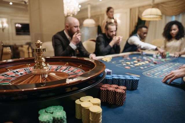 Meja roulette dengan pemain di kasino