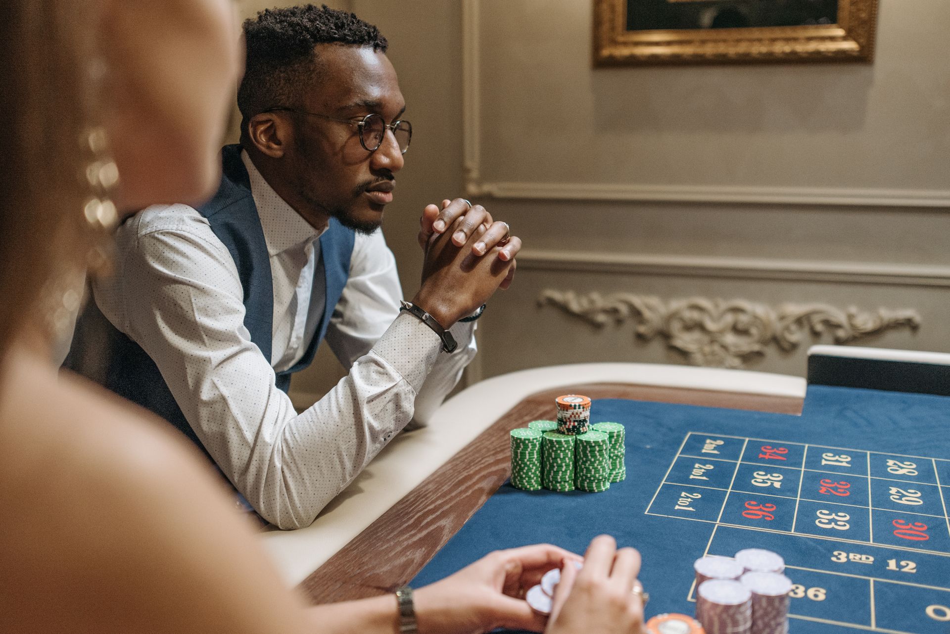 Man concentrating at a casino table with poker chips, captured indoors.