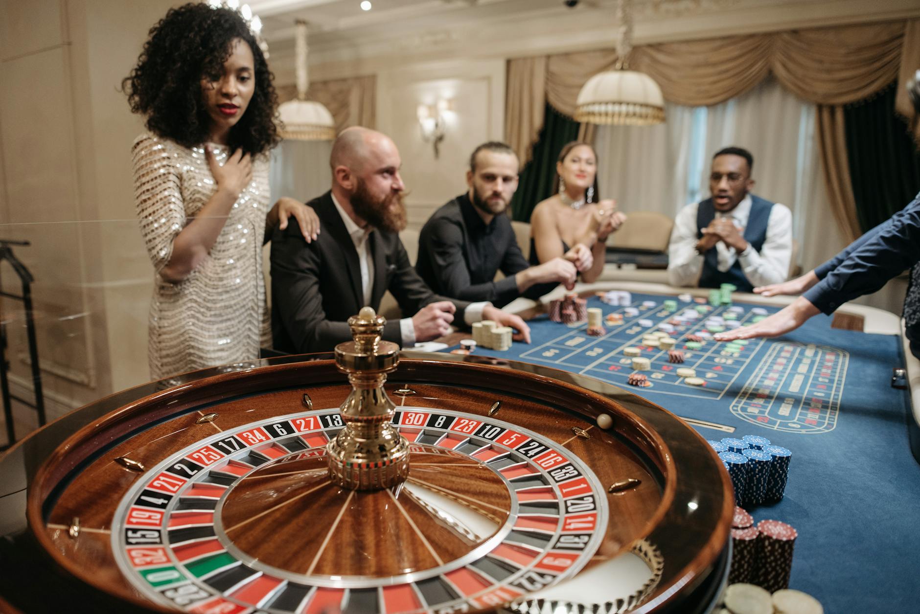 A glamorous group enjoying an exciting night at the casino with roulette and gaming chips.