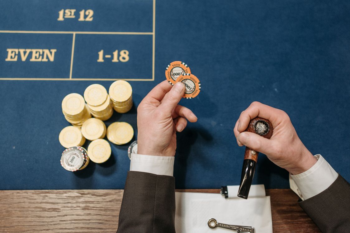 Free Overhead view of a casino table with poker chips and a tobacco pipe, depicting a gambling scene. Stock Photo