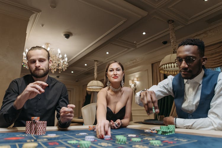 Men And A Woman Playing Poker 