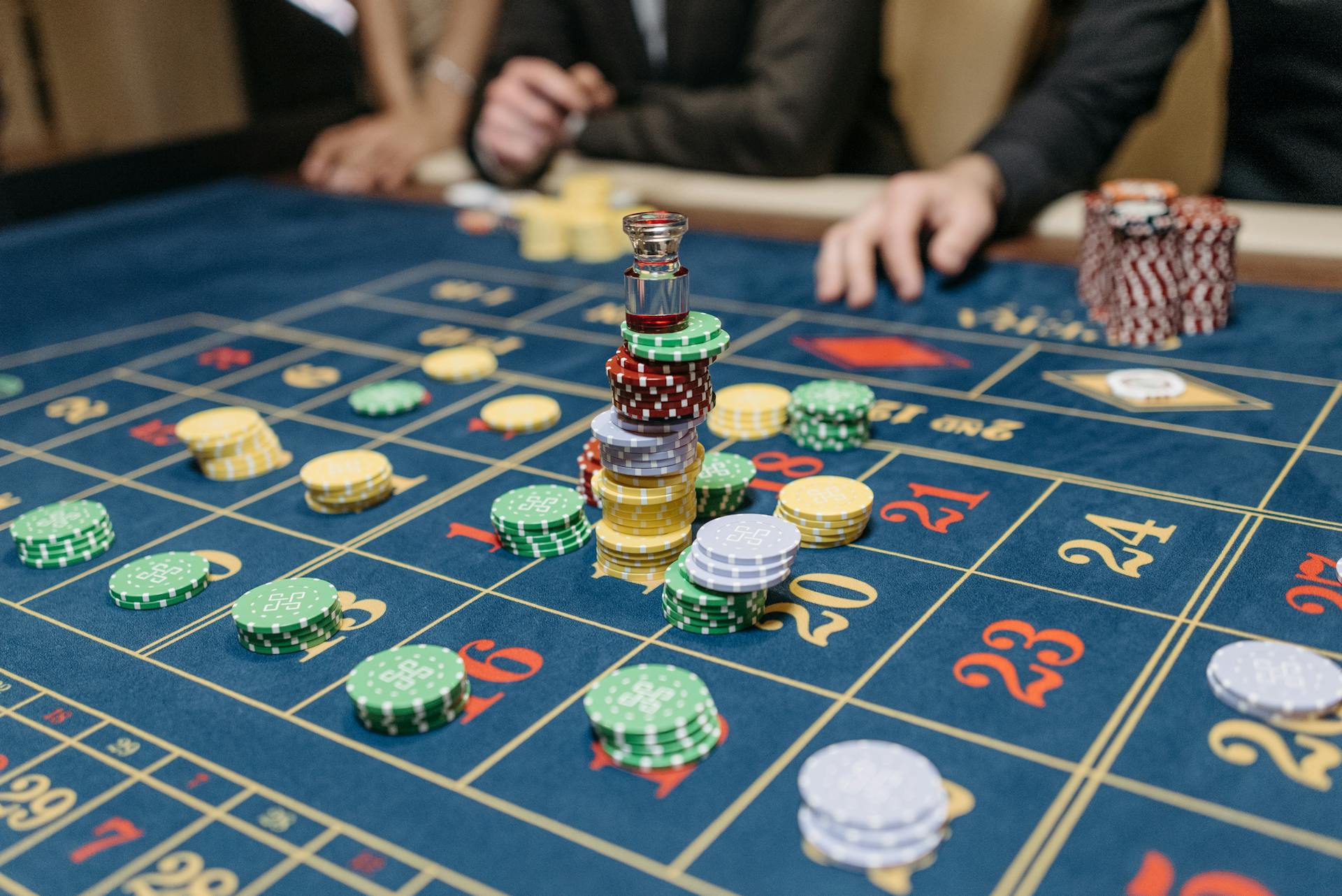 A casino table featuring stacked gaming chips and a roulette layout, suggesting gameplay.