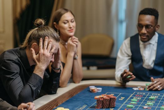 Tense and exciting moment at a casino roulette table with three diverse gamblers.