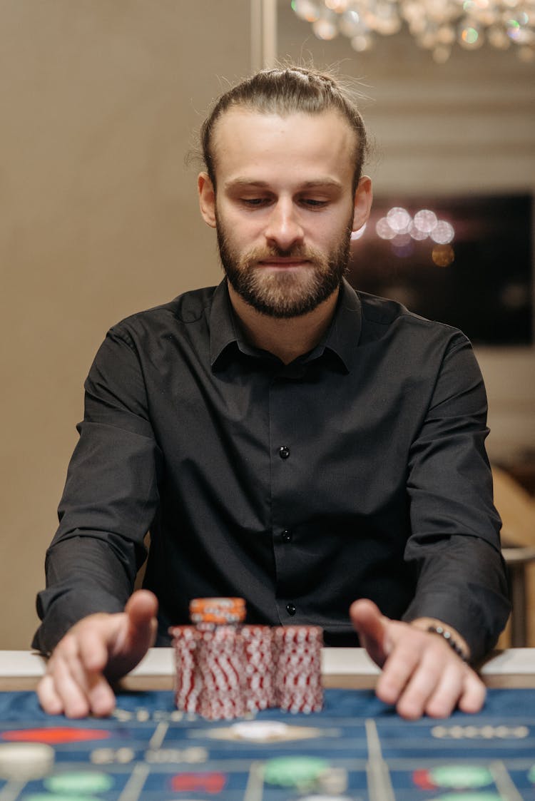 Bearded Man Looking At His Casino Tokens