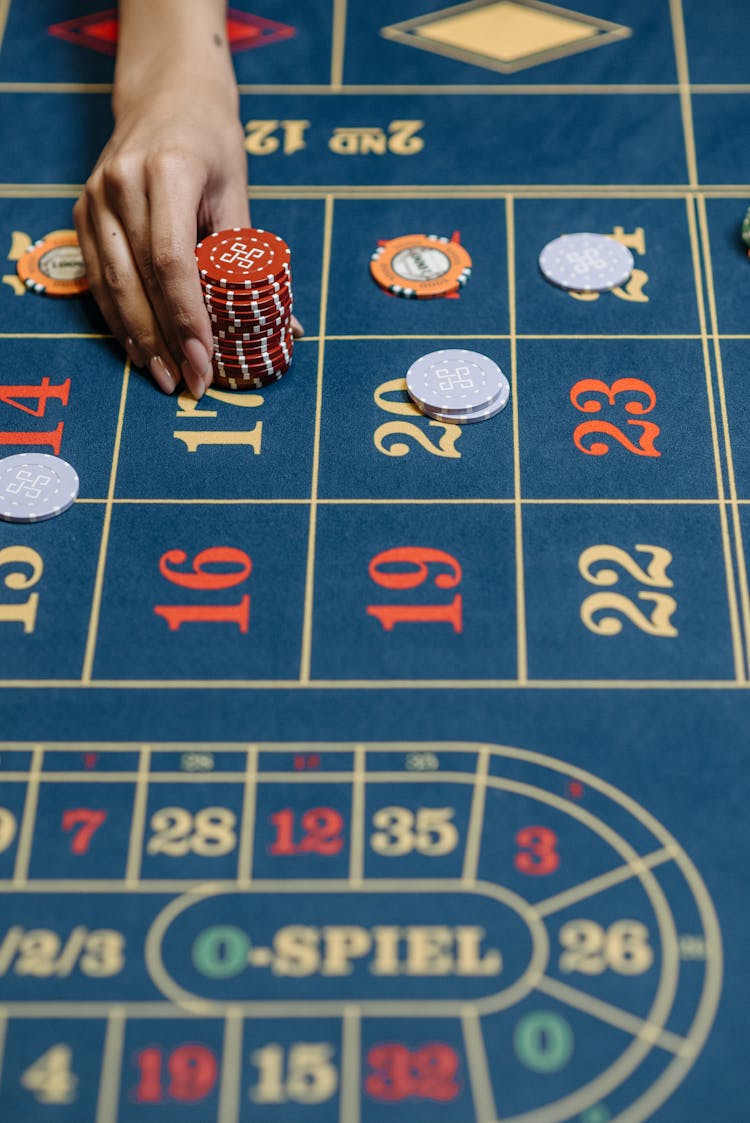 A Person Betting Chips In The Casino