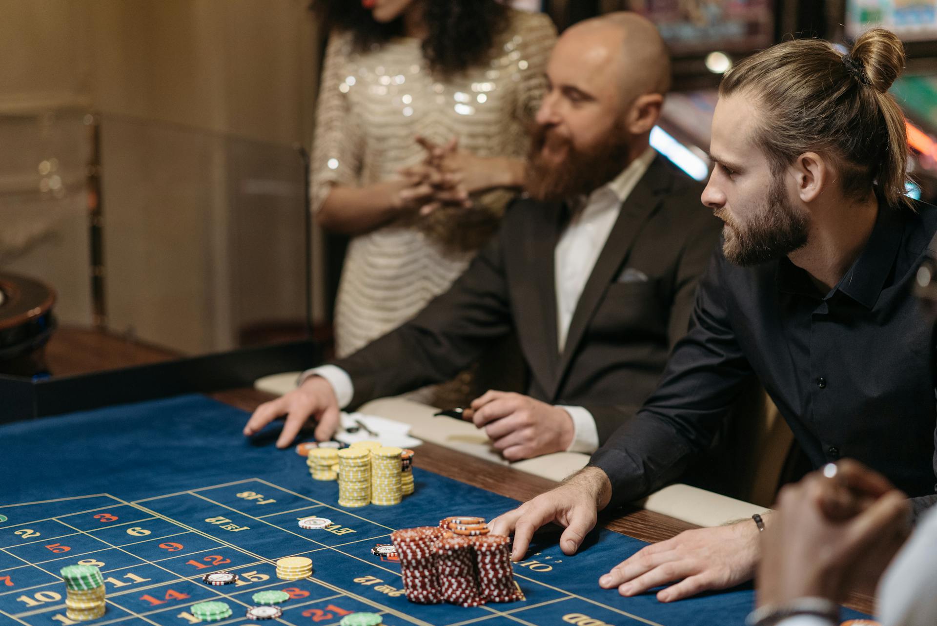 Group of adults enjoying a thrilling roulette game at a casino table.