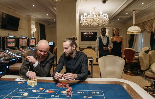 Glücksspiel mit Pokerkarten und Münzen auf einem Casino Tisch