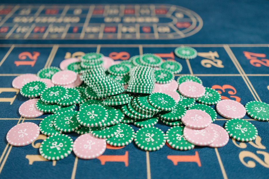 Close-up of a roulette table with a pile of green and pink poker chips.
