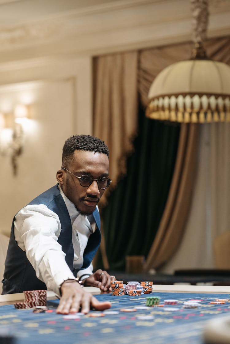 A Player Placing A Bet On Roulette Table