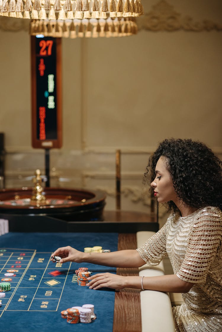 A Woman Betting Stack Of Chips On A Roulette Table