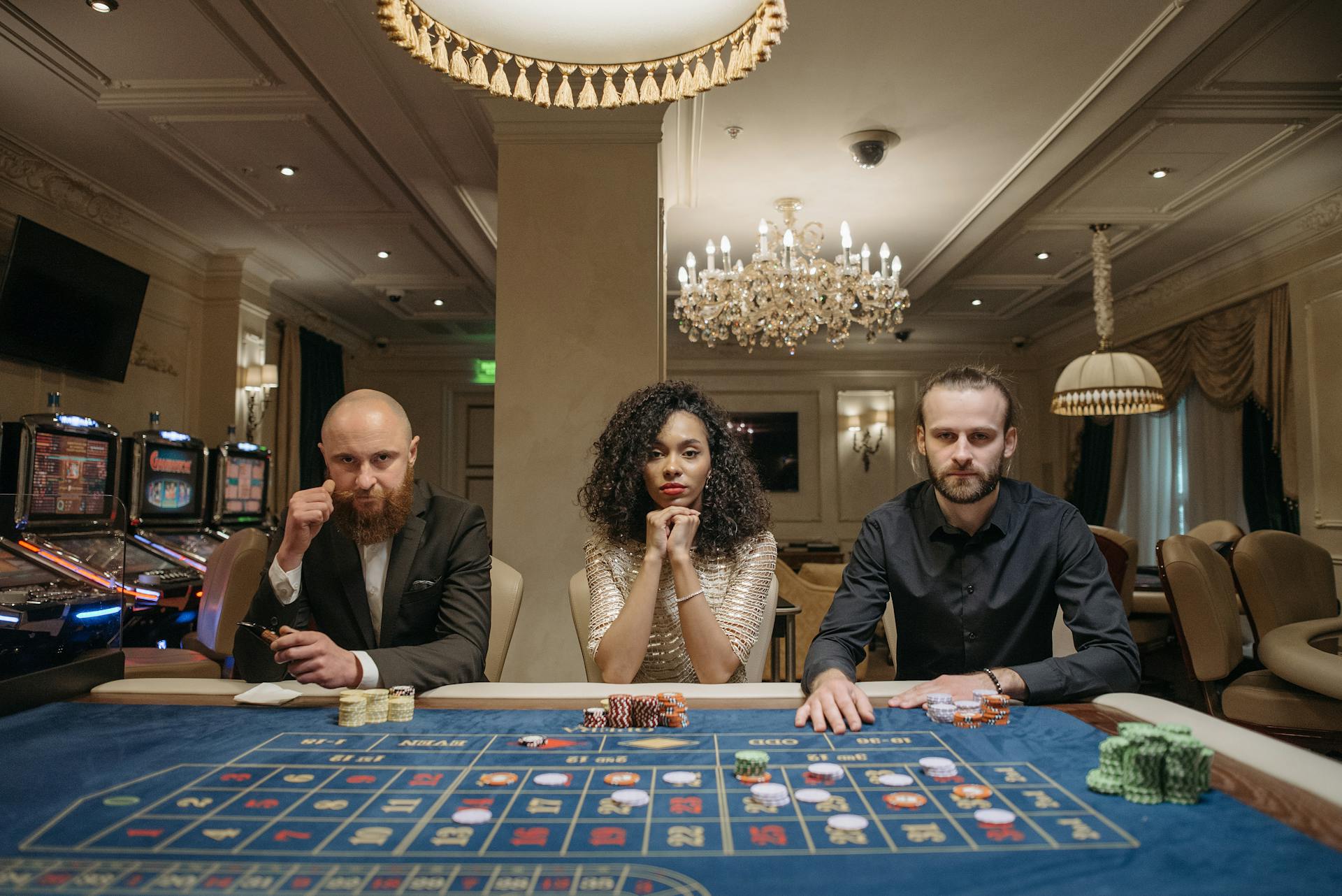 A Woman and Men Sitting at a Gaming Table with Stacks of Casino Tokens