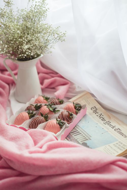 Free Elegant setup with chocolate-covered strawberries and flowers in pink tones. Stock Photo