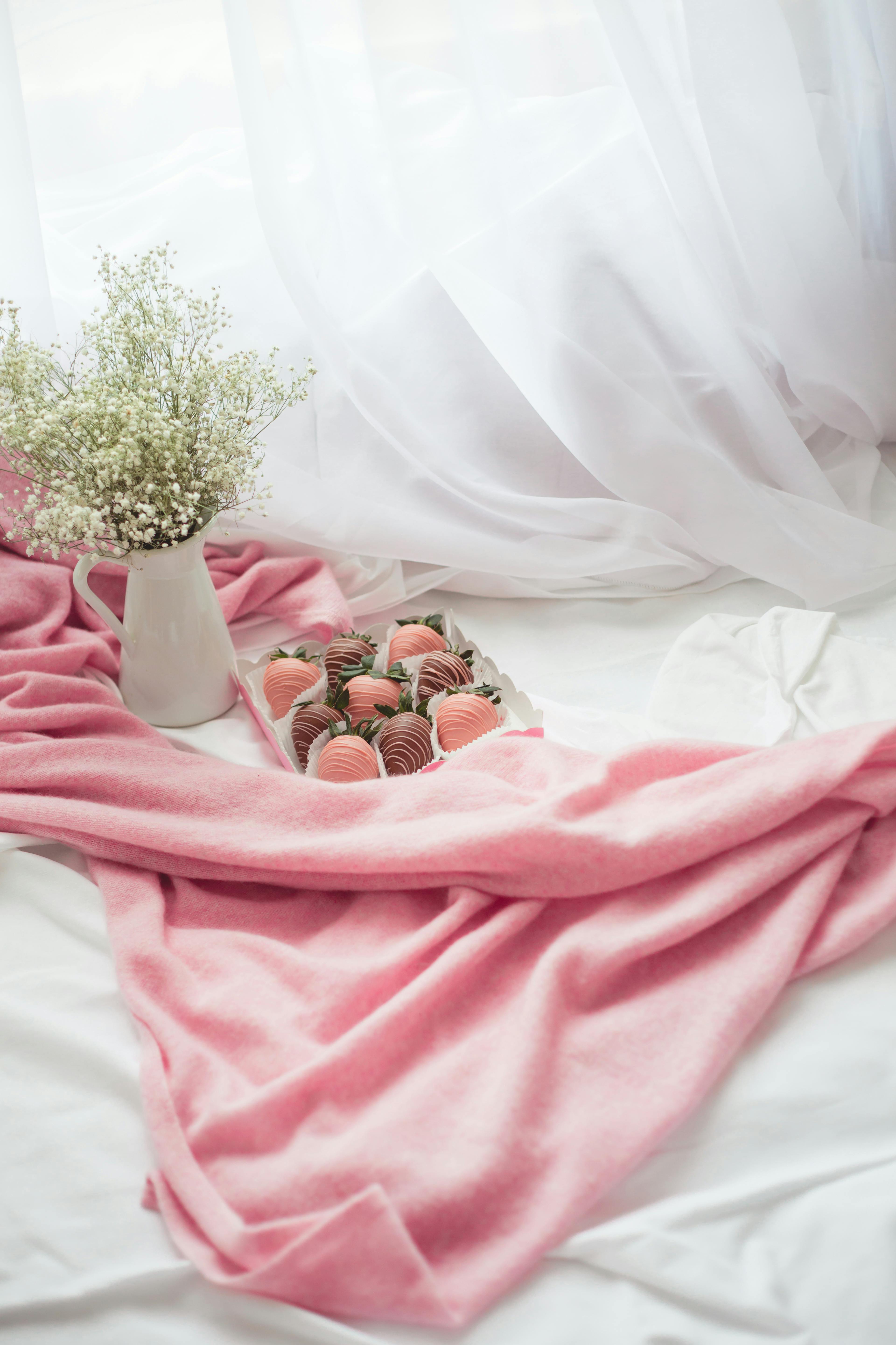 A charming composition featuring chocolate strawberries and baby's breath on pink fabric.