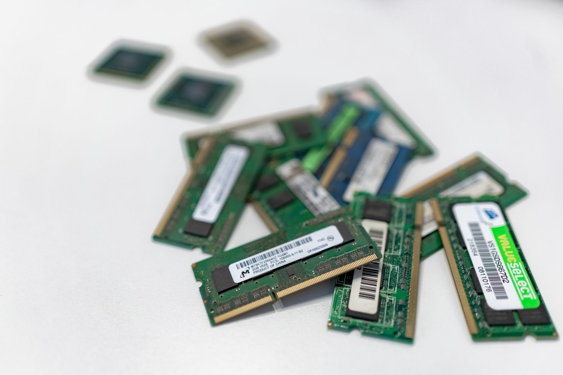 Assorted RAM modules scattered on a white surface, showcasing technology components.