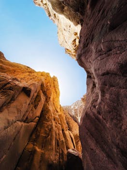 Stunning view of sandstone cliffs reaching toward a clear blue sky, captured in a vertical shot.