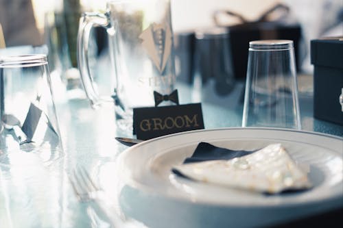 Assiette Ronde En Céramique Blanche Près De Tasses En Verre Et Signe De Marié