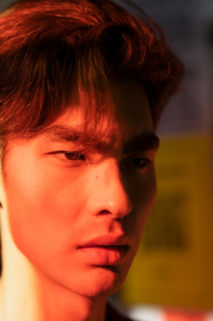 Close-up portrait of a serious young man with red hair, outdoors.