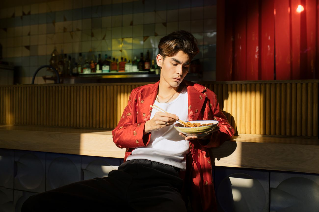 Still from the episode: host eating noodles with chopsticks at the counter. Photo by cottonbro studio on Pexels