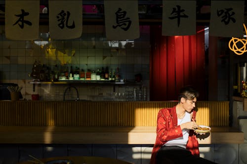 Man Eating Bowl of Noodles