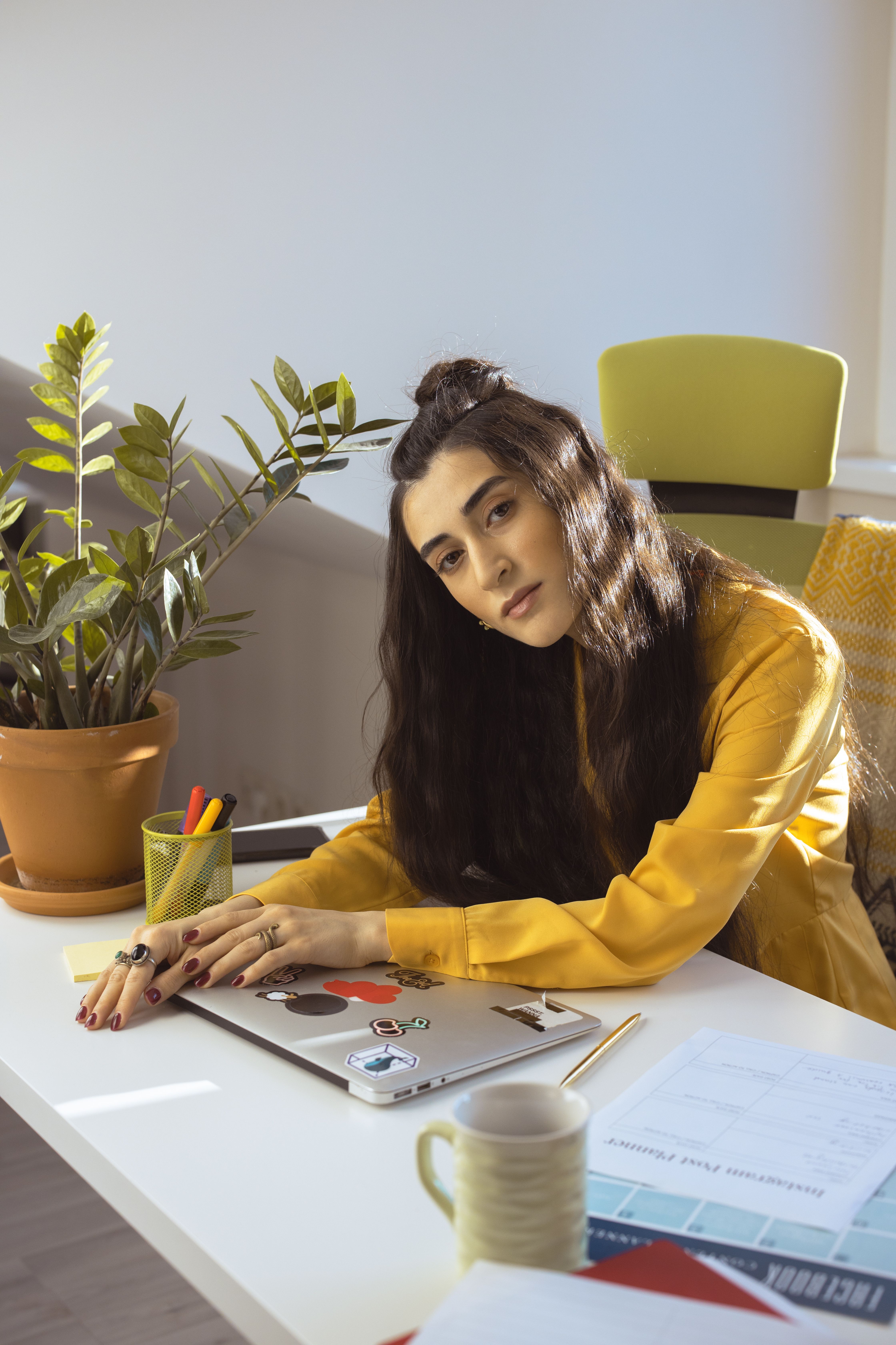 Woman in a yellow outfit at a desk, showing how saturated colour can still look composed in a work setting.