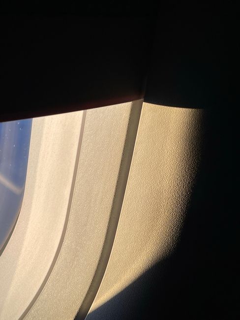 Elegant play of light and shadow through airplane window in flight.