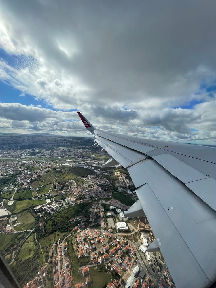 Wing Of Plane Flying Over City 