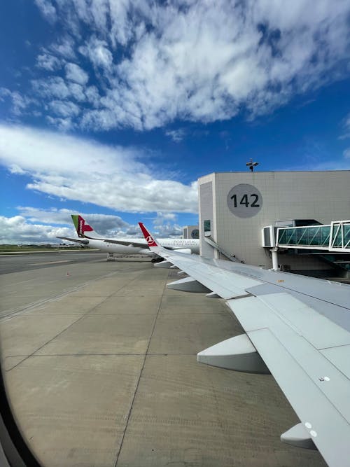 White Airplane Wing under Blue Sky and White Clouds