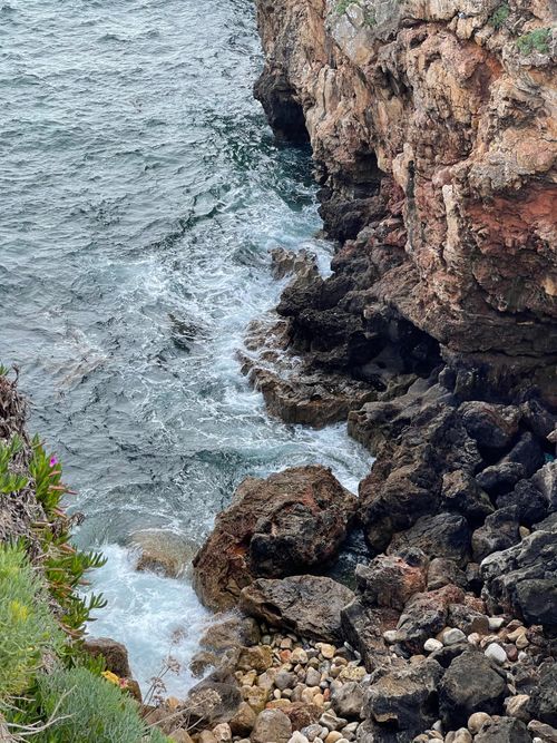 Free A rugged coastline with waves crashing against rocky cliffs and shoreline. Stock Photo
