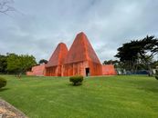 Orange Concrete Structure on Green Grass Field under Gloomy Sky