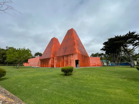 Orange Concrete Structure on Green Grass Field under Gloomy Sky
