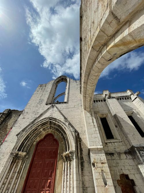 Free Low angle view of an ancient stone cathedral with blue sky, highlighting Gothic arches. Stock Photo