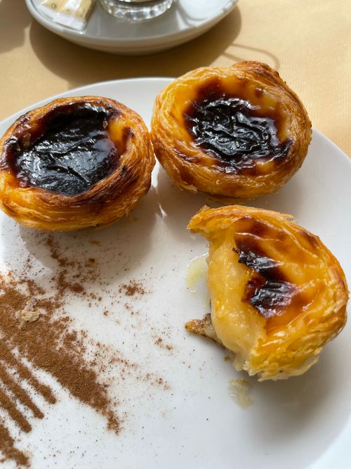 Free Close-up of Portuguese custard tarts with cinnamon on a white plate. Stock Photo