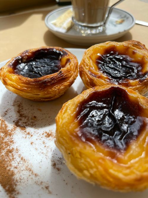 Free Close-up of freshly baked Pastel de Nata, showcasing its creamy texture and crispy crust on a white plate. Stock Photo