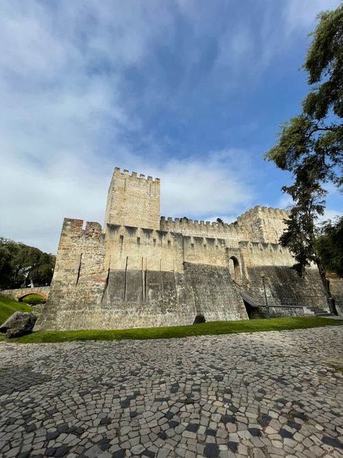 Gratis Vista ad angolo basso del storico Castello di San Giorgio contro un cielo blu con nuvole. Foto a disposizione