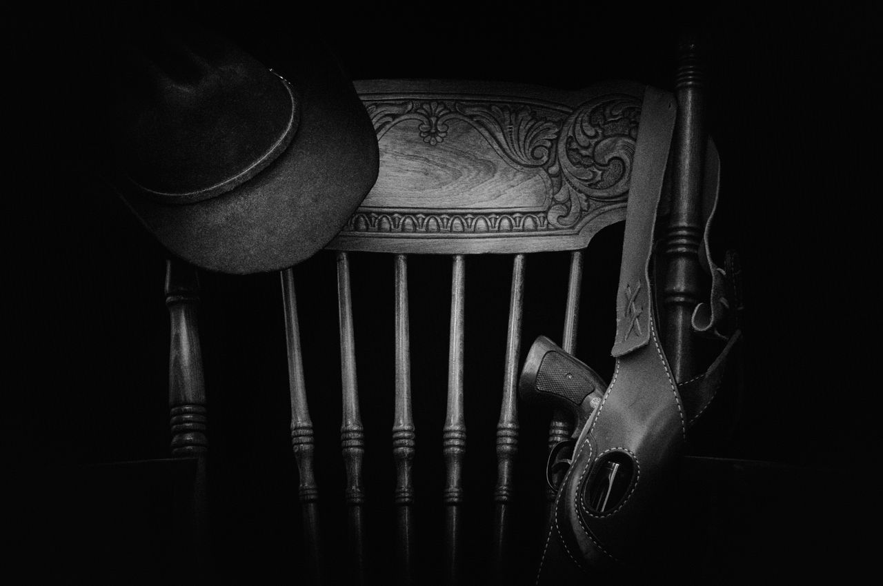 a classic western themed black and white still life featuring a hat wo