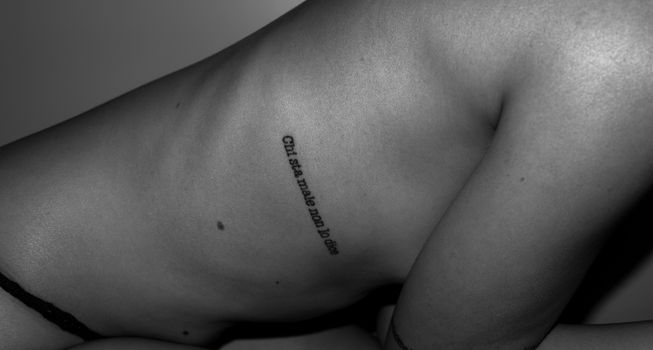 Artistic black and white photograph showcasing a tattooed side with unique body art design.