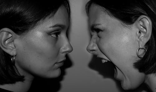 Grayscale Photo of Two Women Looking At Each Other