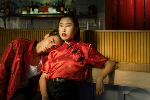 Free Attractive couple in red outfits showcasing modern Asian fashion indoors, exuding style and elegance. Stock Photo