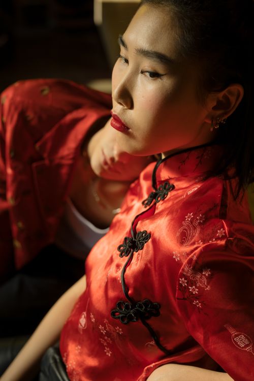 Free A fashionable couple in traditional Chinese clothing, bathed in soft indoor lighting. Stock Photo